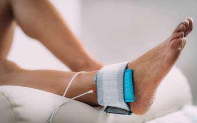 TENS, Transcutaneous Electrical Nerve Stimulation in Physical Therapy. Therapist Positioning Electrodes onto Patient's Ankle Joint