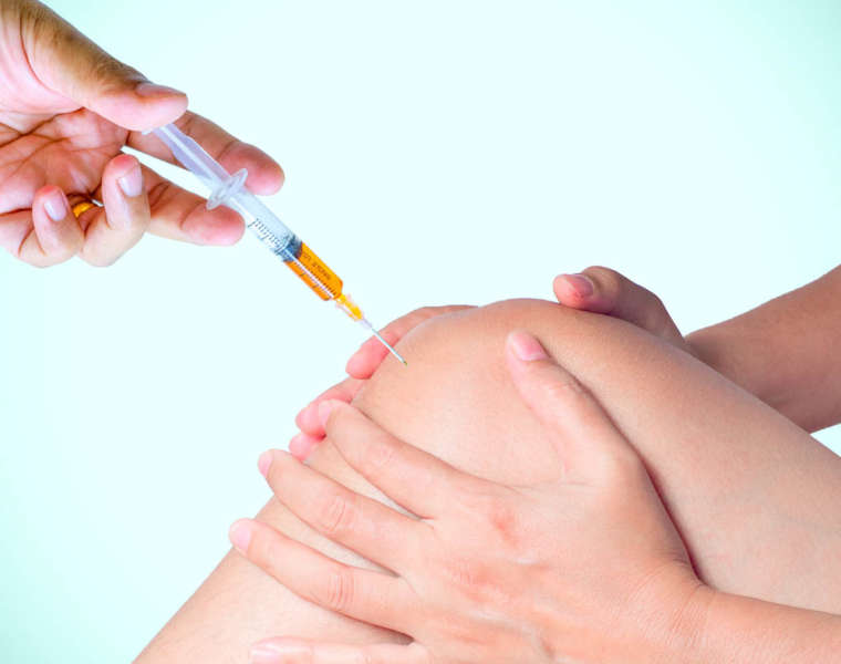 Doctor hand holding syringe of platelet rich plasma for injectio Doctor hand holding syringe of platelet rich plasma for injection to knee.